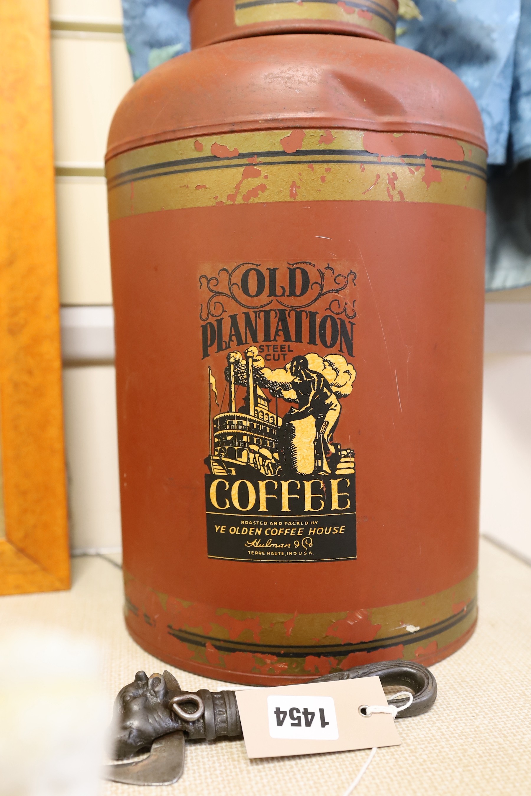 A large toleware tin coffee canister and a novelty iron can opener, canister 38cms high